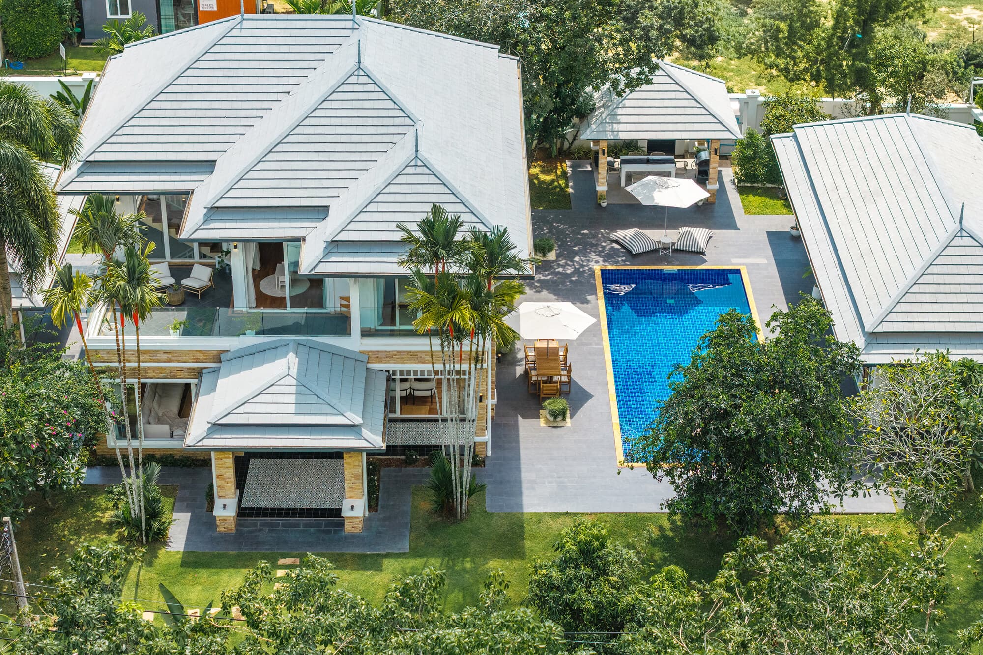 ภาพมุมสูงกลางวันของหลังคา สวน เทอร์เรซ และสระ Villa Bussaba